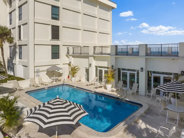 a house view with pool and chairs