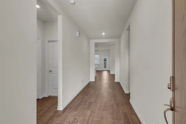 a view of a hallway with wooden floor