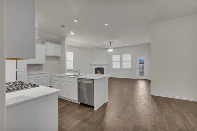 a kitchen with a sink cabinets and wooden floor