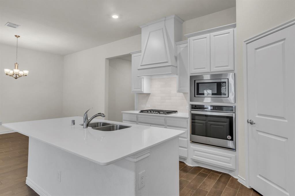 3106 Maverick Drive Forney, TX 75126 - Photo 10 of 29 a kitchen with a sink a stove and refrigerator