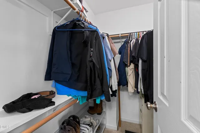a view of walk in closet with clothes and shoes