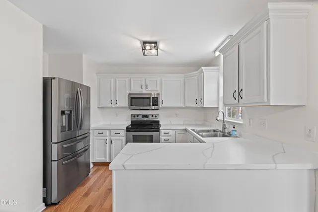 a kitchen with stainless steel appliances a refrigerator sink and microwave