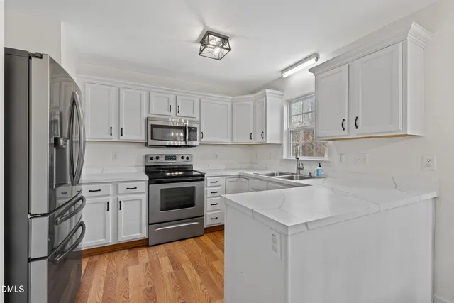 a kitchen with cabinets stainless steel appliances and a counter space