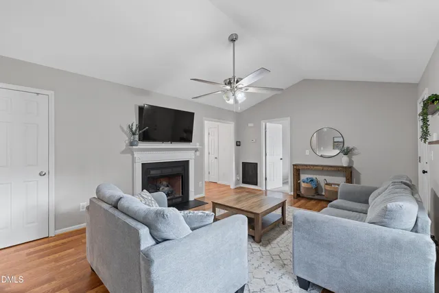 a living room with furniture a fireplace and a flat screen tv