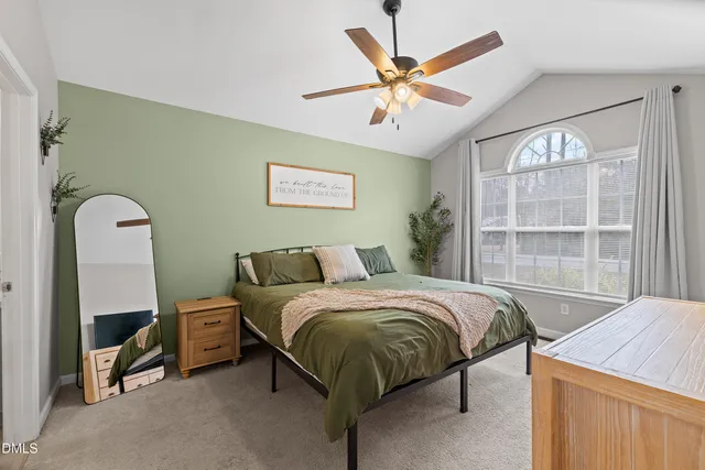 a bedroom with a bed a window and a chandelier