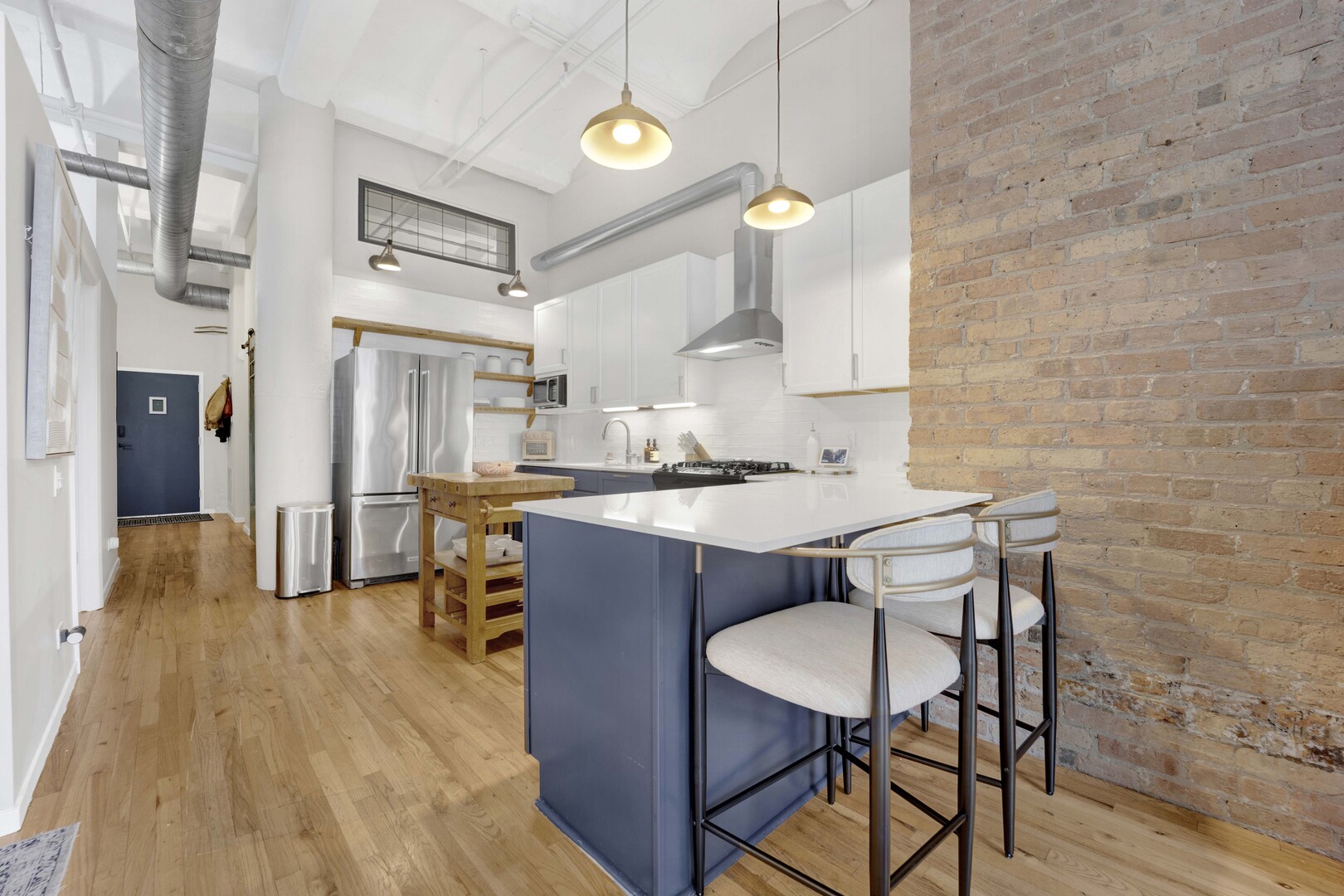 1000 West Washington Boulevard, Unit 305 Chicago, IL 60607 - Photo 6 of 21 a kitchen with stainless steel appliances a dining table chairs and wooden floor