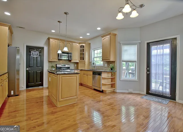 a kitchen with granite countertop a refrigerator and microwave