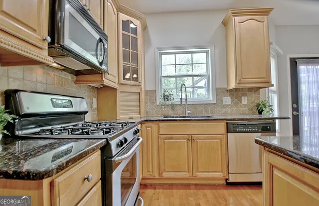 a kitchen with stainless steel appliances granite countertop a stove and a sink