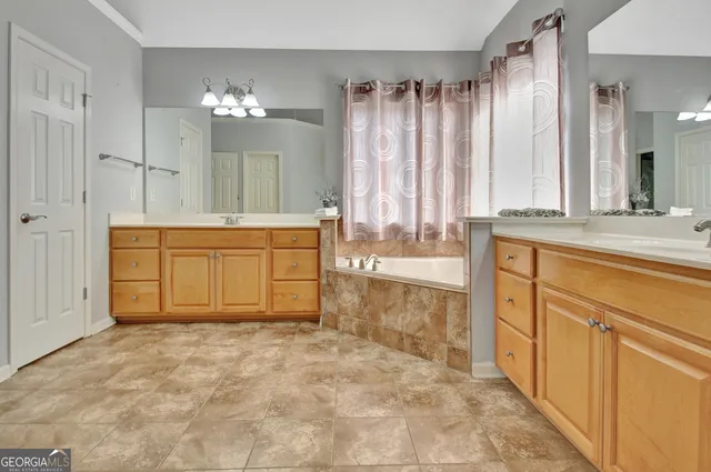 a spacious bathroom with a tub sink and mirror