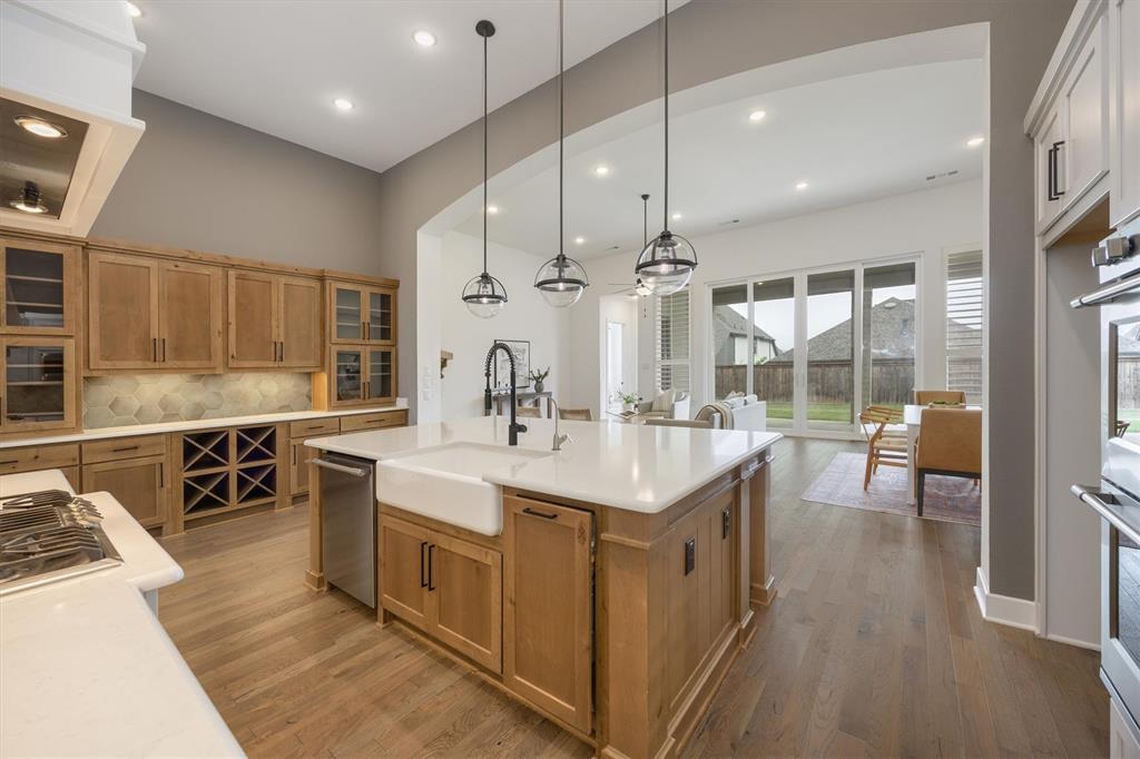 1303 Limestone Ridge Road Mansfield, TX 76063 - Photo 8 of 34 Decorative penant lights adorn the kitchen island.