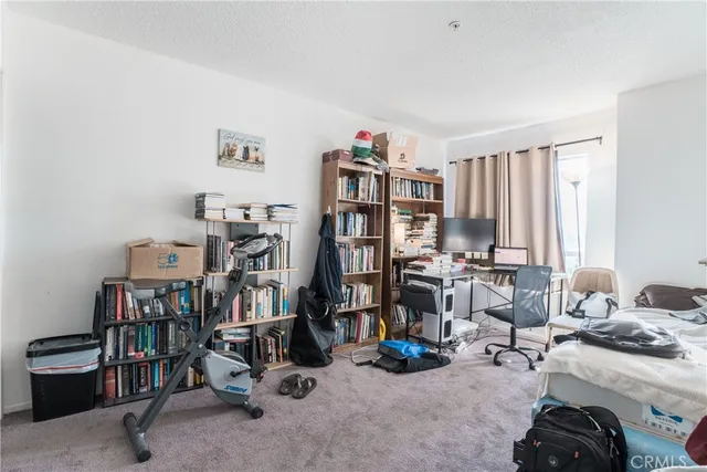 a view of a workspace with furniture and a bookshelf
