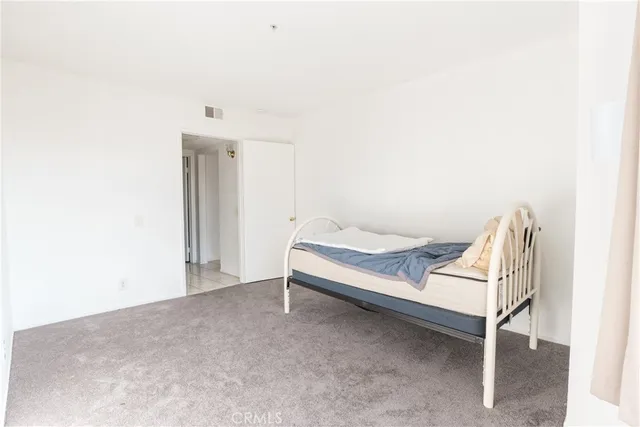 a spacious bedroom with a bed and a cabinets