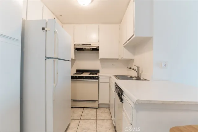 a kitchen with a sink a stove a refrigerator and cabinets