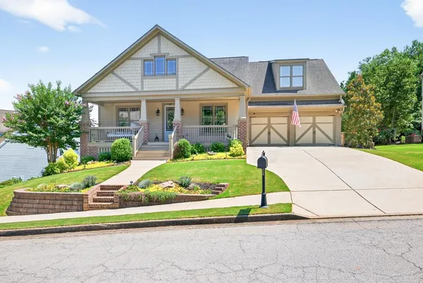 a view of a house with a yard and potted plants