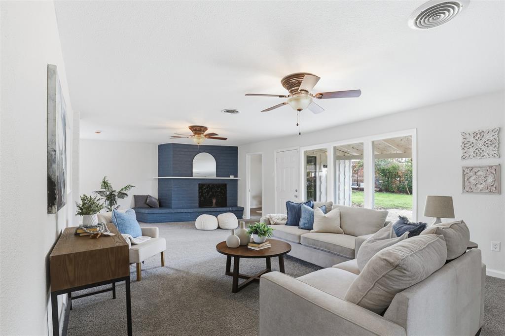 a living room with furniture ceiling fan and a fireplace