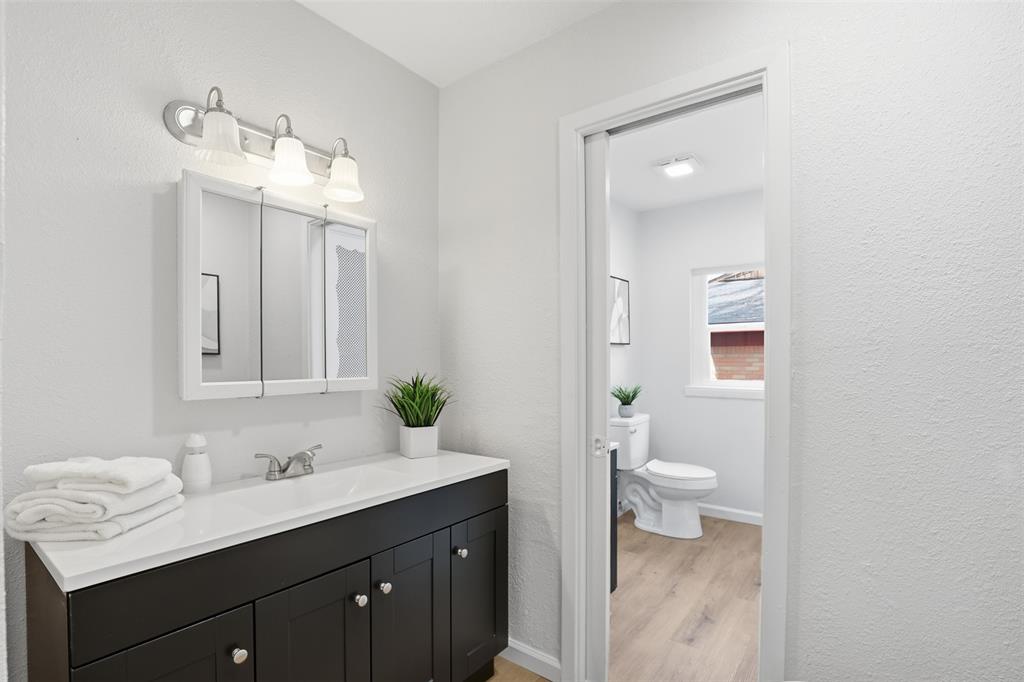 2212 Briardale Road Fort Worth, TX 76119 - Photo 16 of 25 a bathroom with a sink a toilet and a mirror