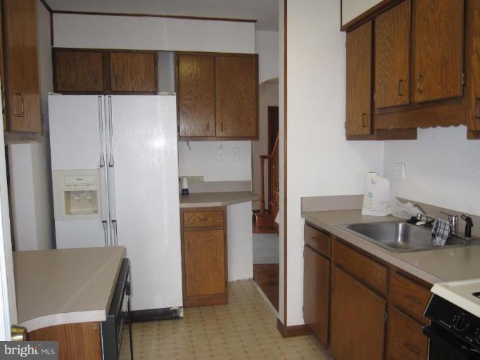 7917 34th Street Rosedale, MD 21237 - Photo 20 of 23 a kitchen with a refrigerator and cabinets