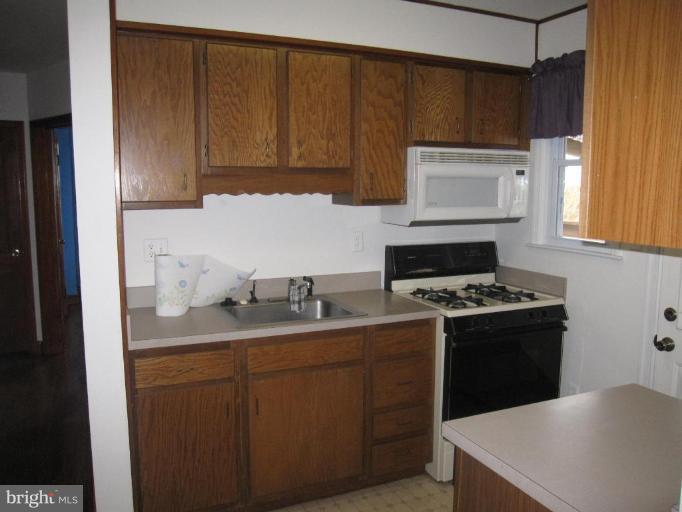 7917 34th Street Rosedale, MD 21237 - Photo 21 of 23 a kitchen with a sink stove top oven and cabinets