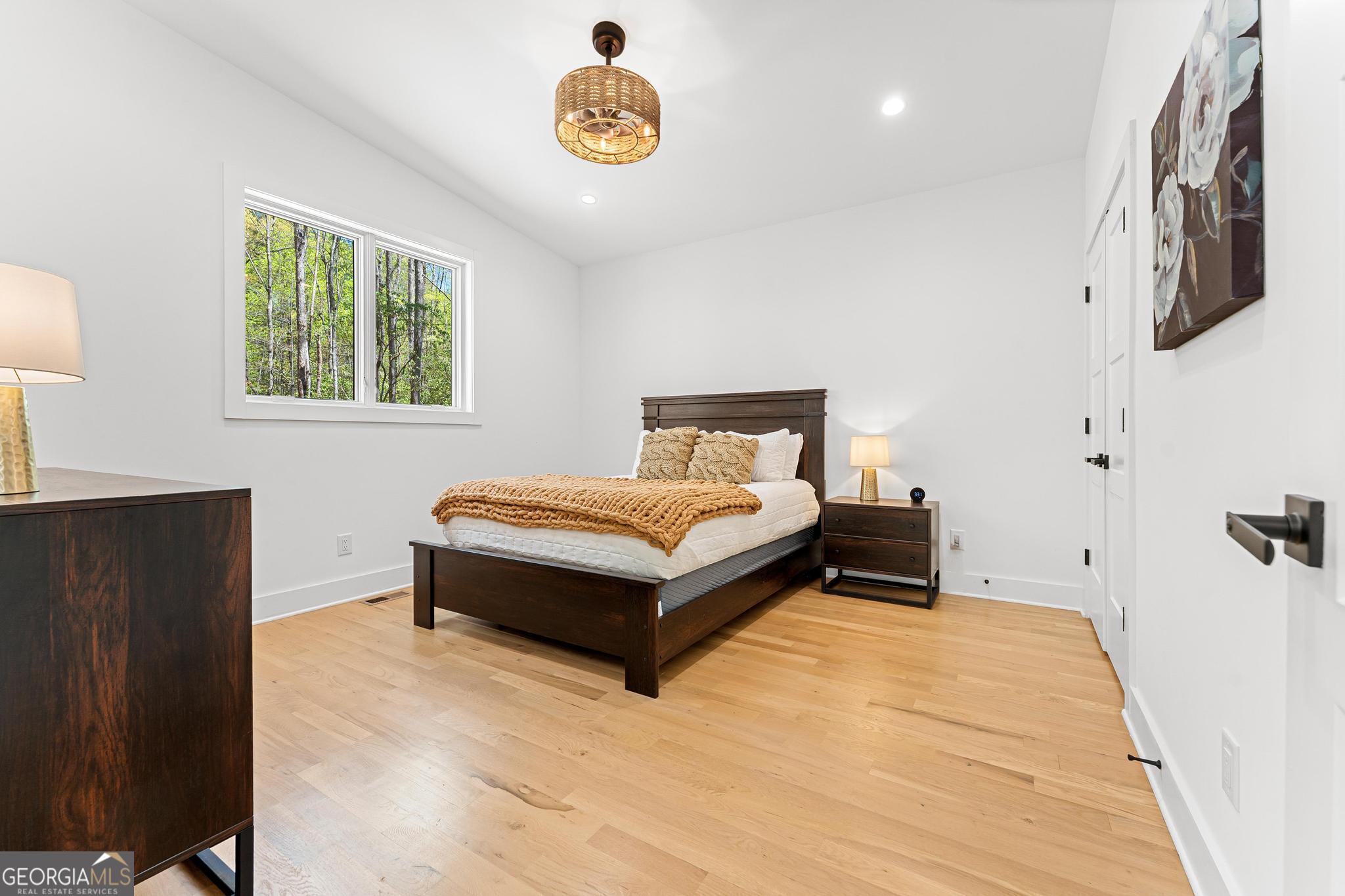 150 Clarice Lane Sautee Nacoochee, GA 30571 - Photo 22 of 42 a bedroom with a bed and a chandelier