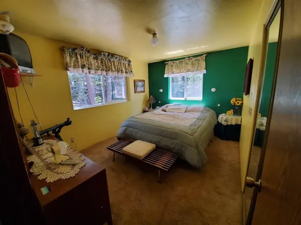 a bedroom with a bed dresser and a window