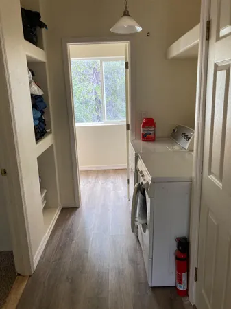 a utility room with wooden floor washer and dryer
