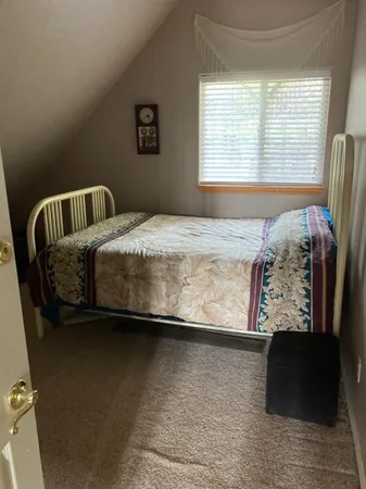 a bed sitting in a bedroom next to a window