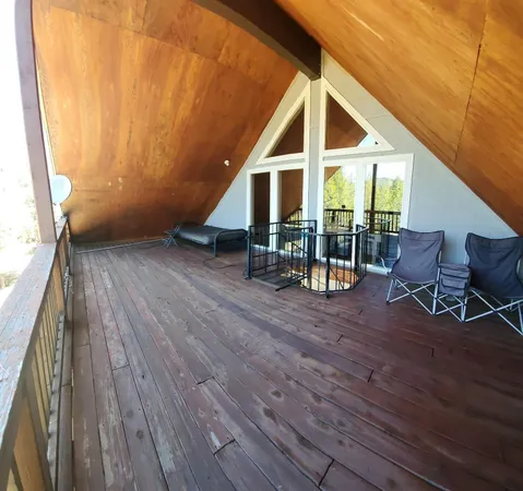 a view of a house with wooden deck and furniture
