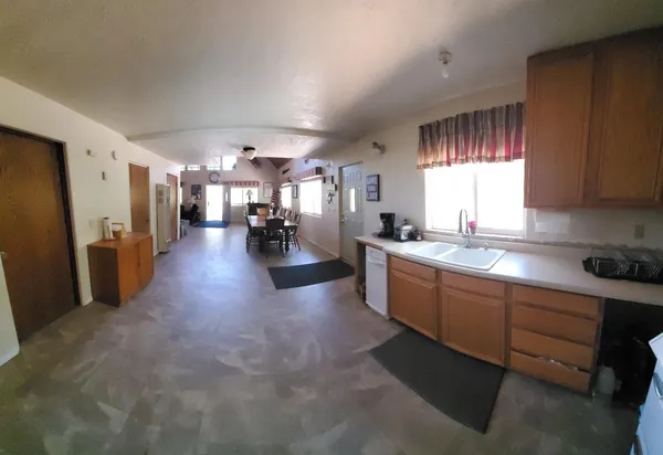 a large white kitchen with lots of counter space and stainless steel appliances