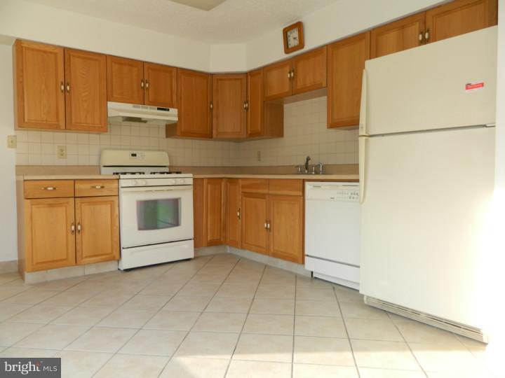 25 Blue Grass Road Clementon, NJ 08021 - Photo 7 of 25 a kitchen with granite countertop a stove a sink and a refrigerator