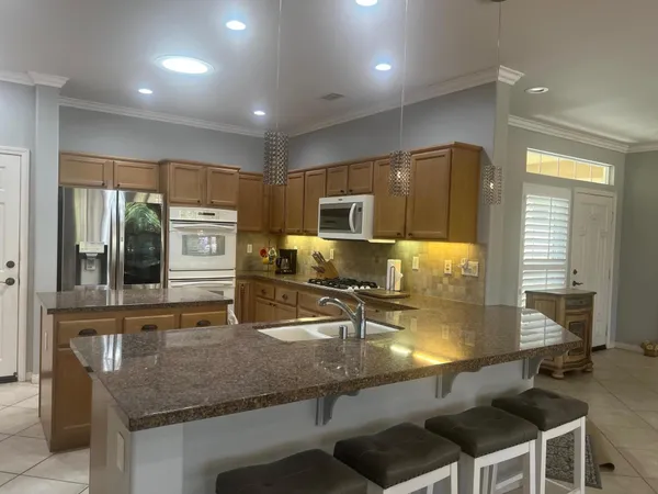 a kitchen with stainless steel appliances granite countertop a sink a stove and a microwave