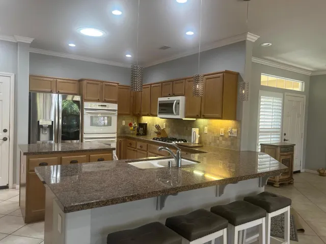 a kitchen with stainless steel appliances granite countertop a sink a stove and a microwave
