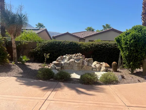 a view of a backyard with table and chairs potted plants
