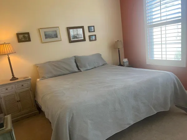 a large bed sitting in a bedroom next to a window