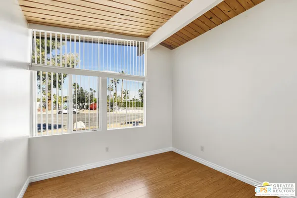 a view of a kitchen with wooden floor and a window