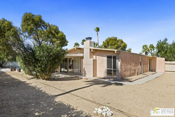 a view of a house with backyard and trees