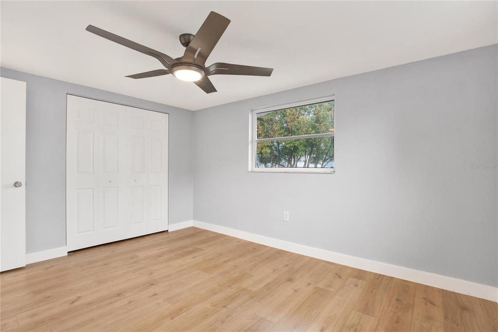 5200 Dove Drive New Port Richey, FL 34652 - Photo 4 of 8 a view of an empty room with wooden floor and a ceiling fan