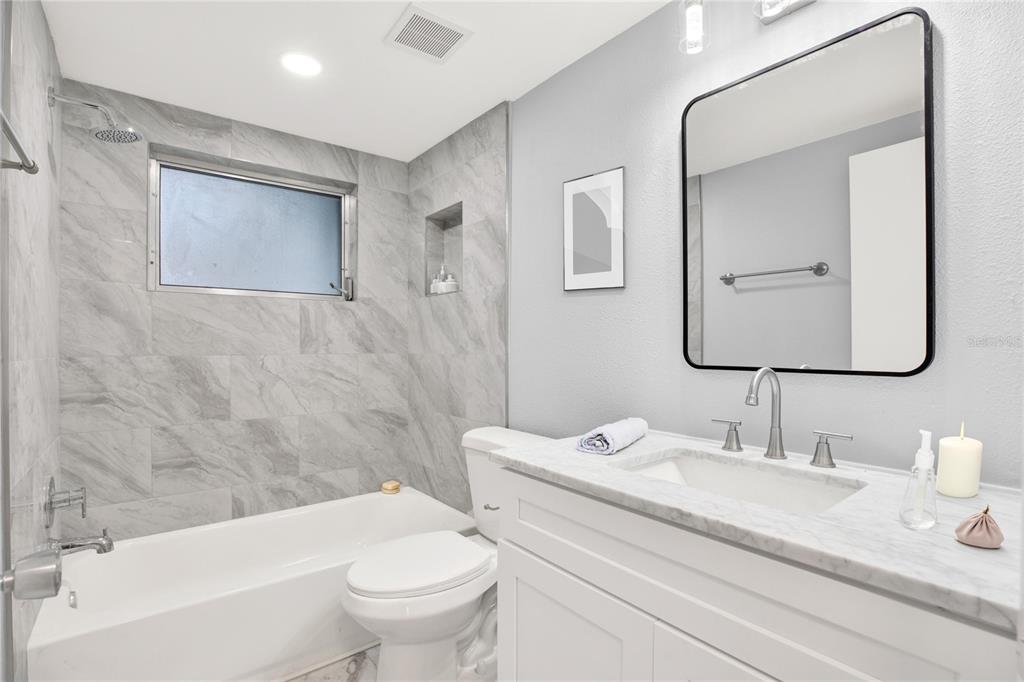 5200 Dove Drive New Port Richey, FL 34652 - Photo 6 of 8 a bathroom with a granite countertop toilet a sink and a mirror