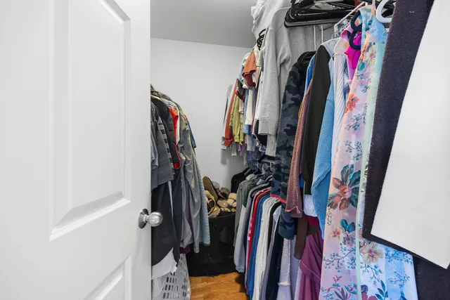 a view of walk in closet with clothes