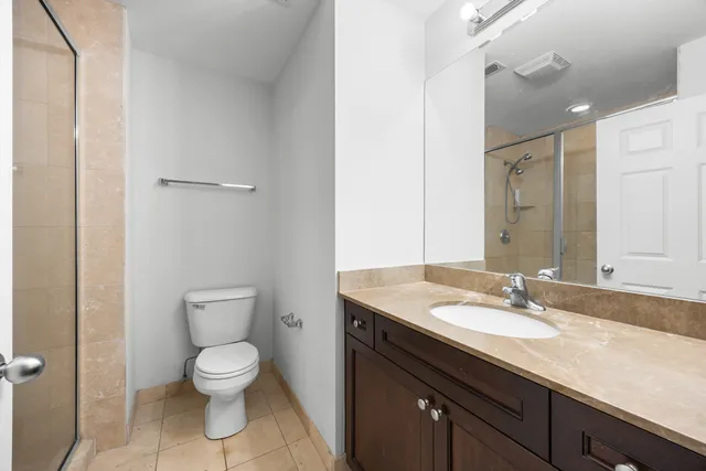 a bathroom with a granite countertop sink a toilet and a mirror