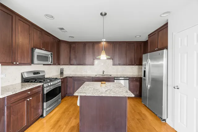 a kitchen with a refrigerator sink and wooden cabinets