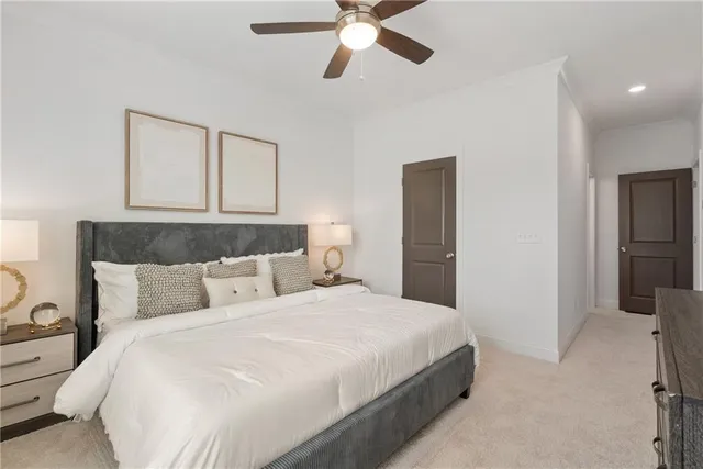 a bedroom with a large bed and ceiling fan