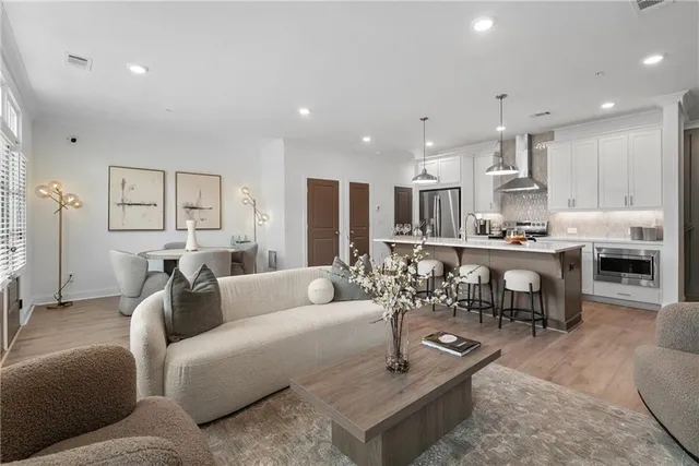 a living room with furniture and a dining table with kitchen view