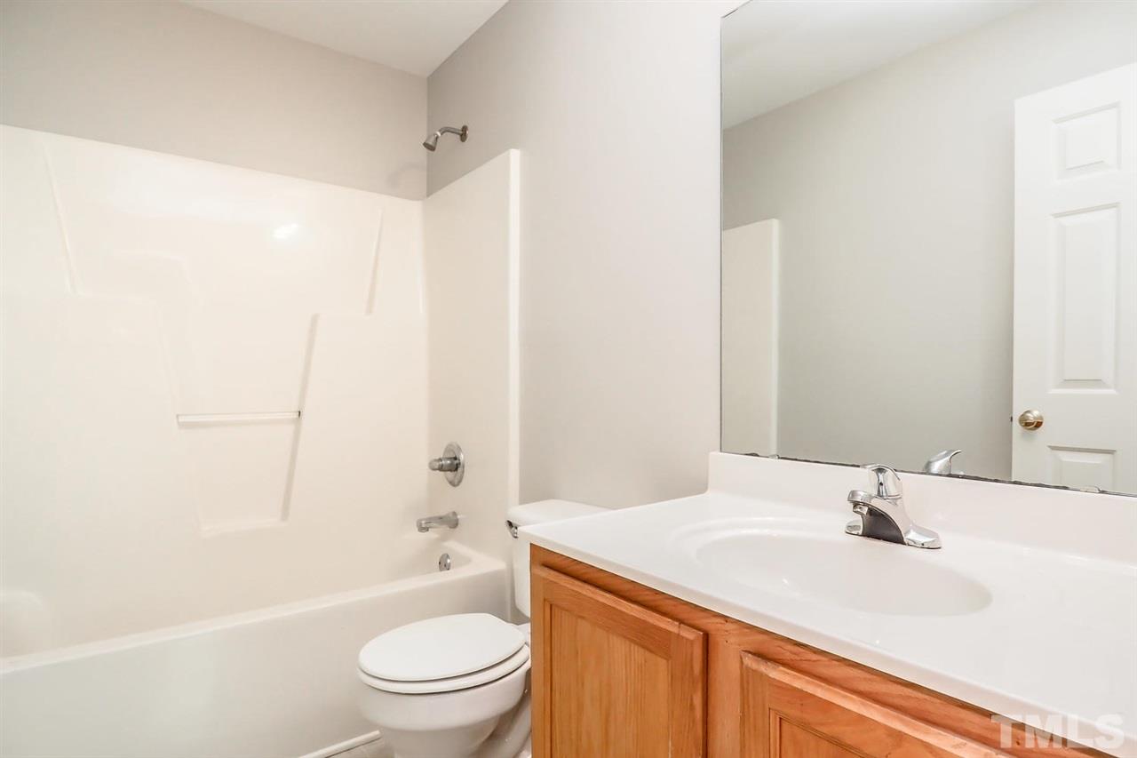 3121 Stedman Drive Raleigh, NC 27607 - Photo 17 of 25 a bathroom with a granite countertop sink a toilet and shower