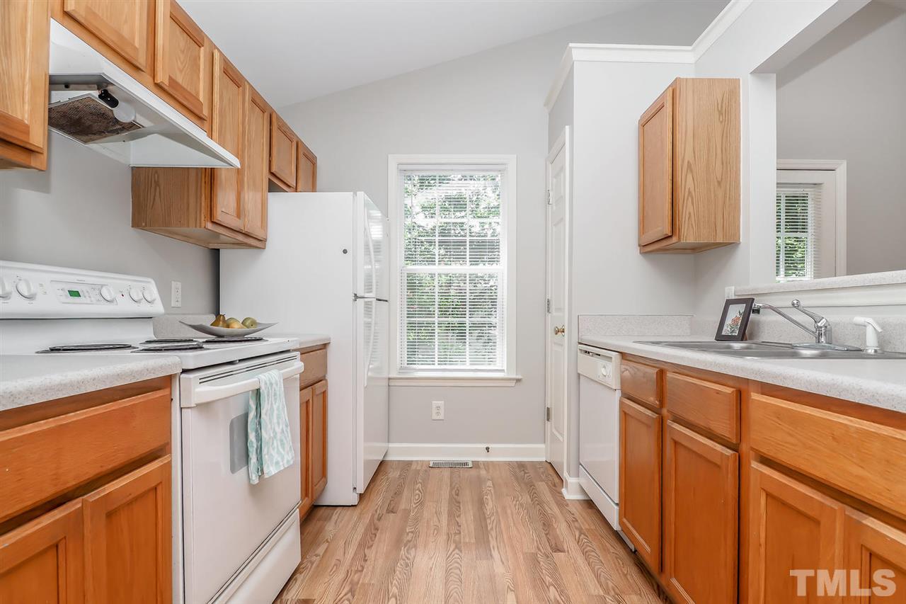 3121 Stedman Drive Raleigh, NC 27607 - Photo 8 of 25 a kitchen with stainless steel appliances a stove a sink dishwasher and wooden cabinets with wooden floor