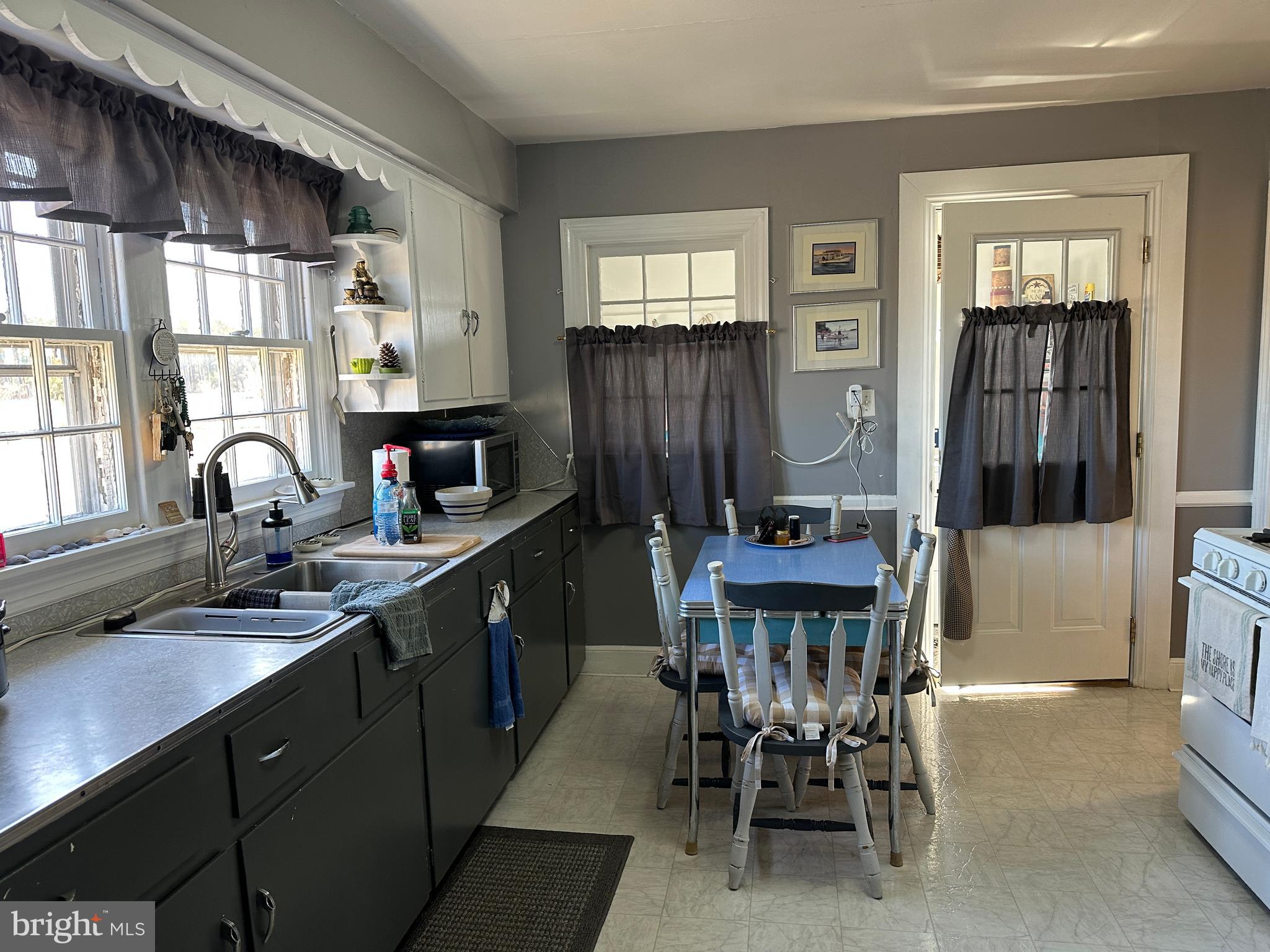 2775 Toddville Road Toddville, MD 21672 - Photo 51 of 59 a kitchen with a table chairs sink and refrigerator