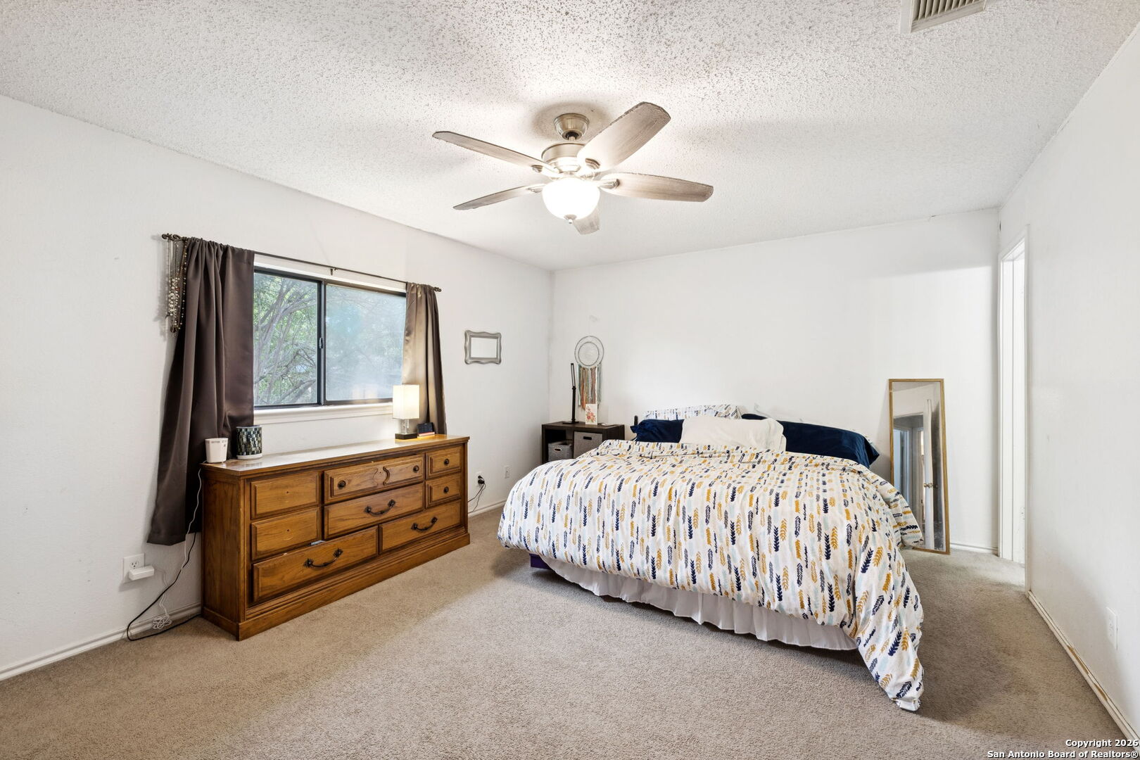 6622 Evenridge Lane San Antonio, TX 78239 - Photo 15 of 21 a bedroom with a bed and a chandelier