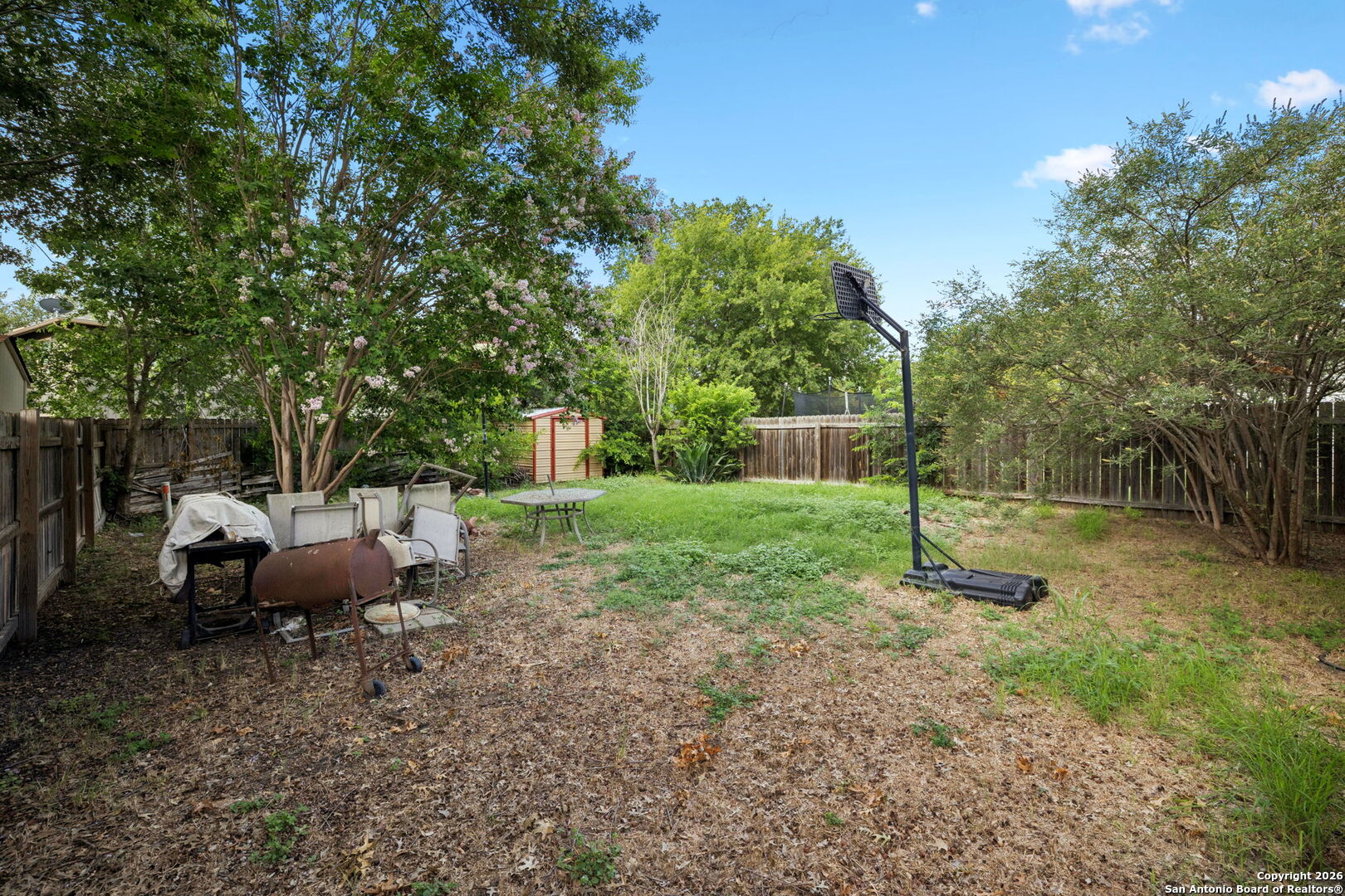 6622 Evenridge Lane San Antonio, TX 78239 - Photo 18 of 21 a view of a backyard with table and chairs a barbeque with a small yard