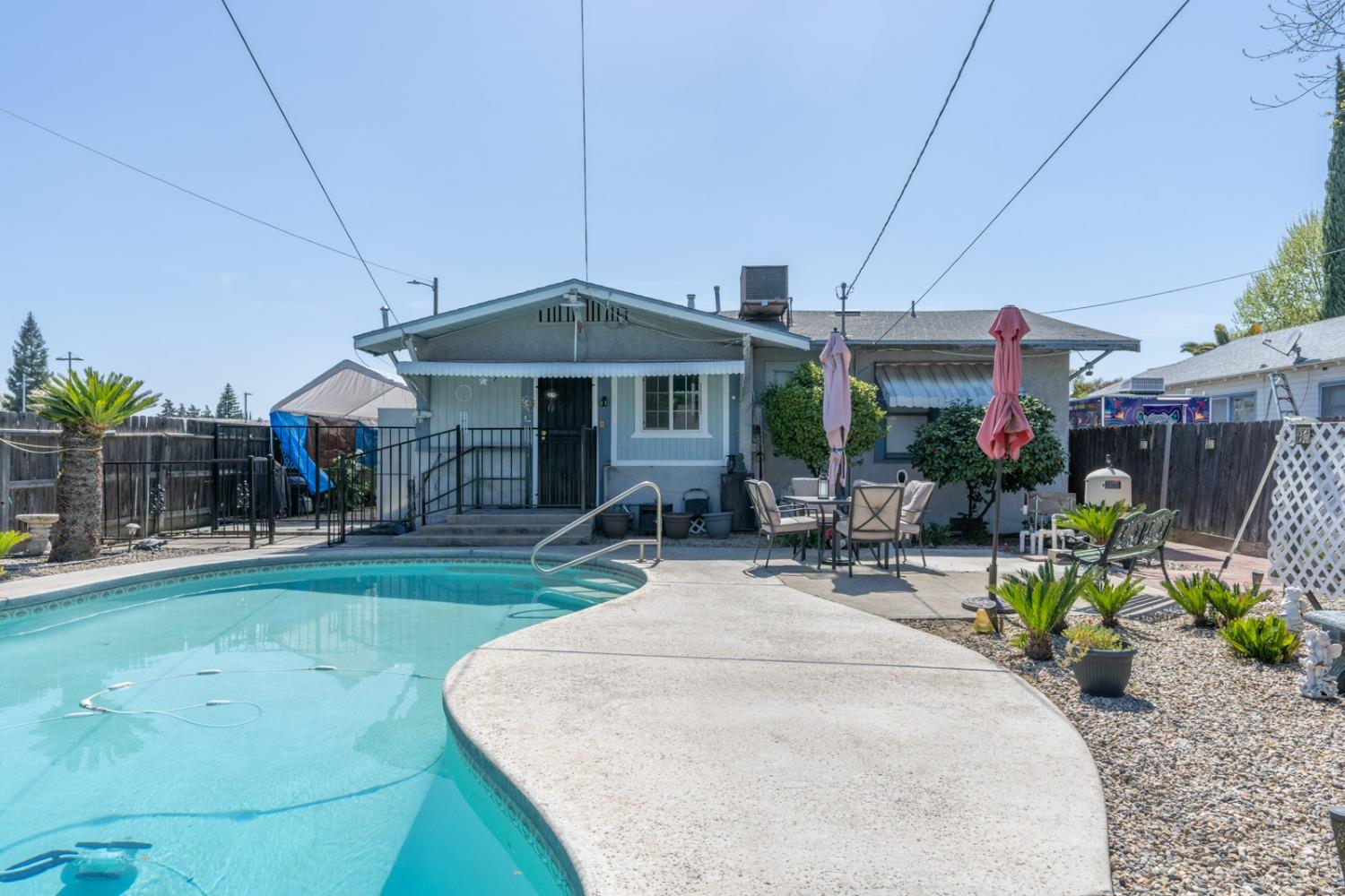 1164 J Street Reedley, CA 93654 - Photo 17 of 43 a patio with a table and chairs under an umbrella