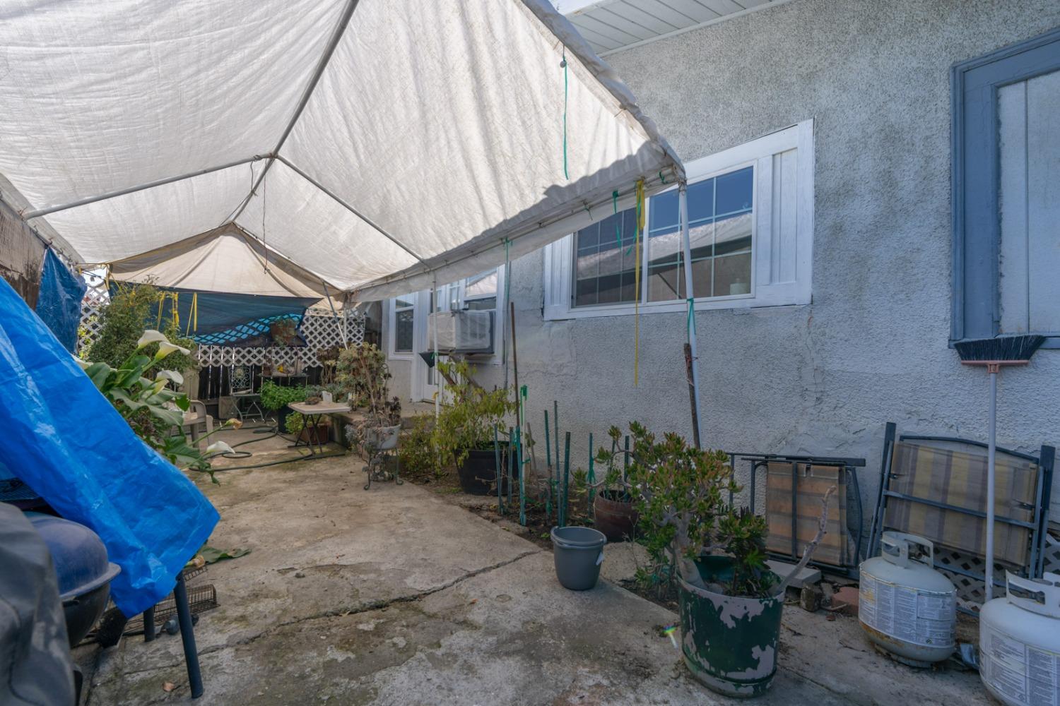 1164 J Street Reedley, CA 93654 - Photo 20 of 43 a backyard of a house with plants and outdoor seating