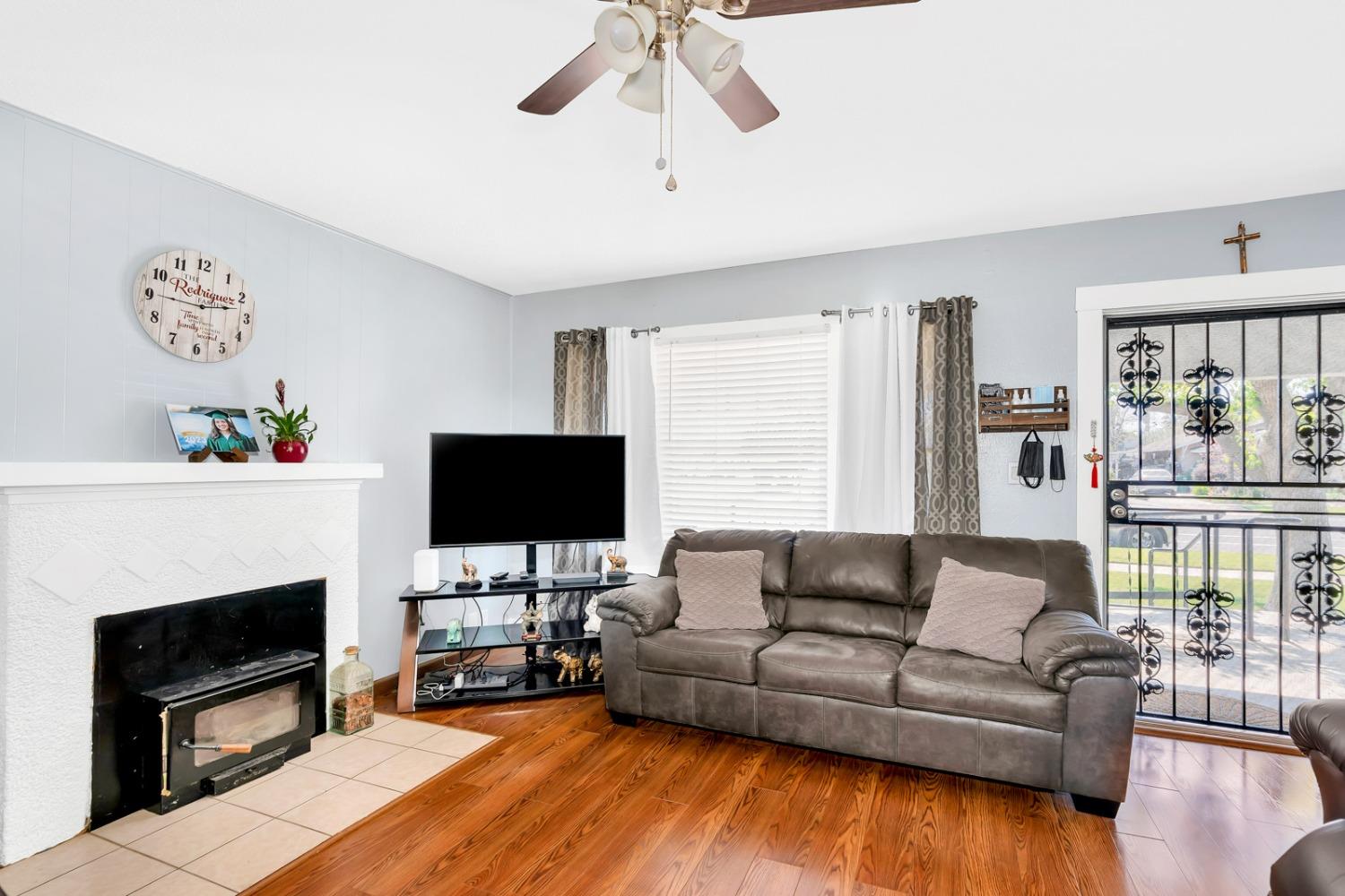 1164 J Street Reedley, CA 93654 - Photo 25 of 43 a living room with furniture a fireplace and a flat screen tv